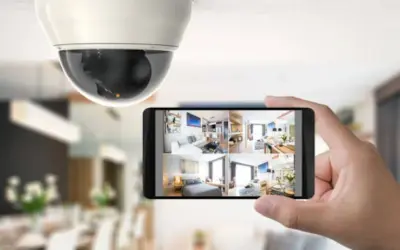 Caméra de surveillance au plafond et smartphone affichant plusieurs flux vidéo, un type d'alarme moderne pour la sécurité domestique.