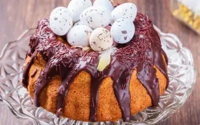 Babka gotowana przepis: puszysta babka z polewą czekoladową, posypką i ozdobiona wielkanocnymi jajeczkami.