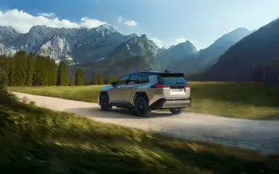 Srebrny Toyota RAV4 pokonuje szutrową drogę w górskim krajobrazie. Idealny do przygód off road.