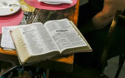 Co Biblia mówi o spowiedzi? Otwarta Biblia na stole, obok talerz i notatki.