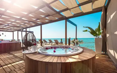 Luksusowy jacuzzi z płatkami róż na tarasie z widokiem na morze. Idealne miejsce na relaks w stylu ultra all inclusive.