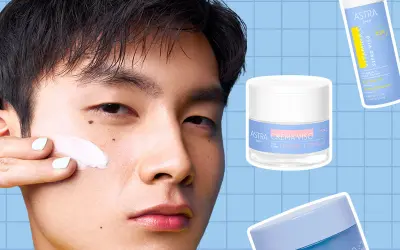 Uomo applica crema viso. Accanto, siero Vitamina C e creme Astra. Scegliere di usare siero senza crema per una routine leggera.