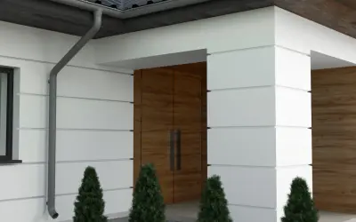Nowoczesny dom z białym tynkiem i drewnianymi elementami. Eleganckie boniowanie elewacji podkreśla architekturę.