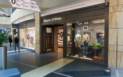 Sklep Marc O'Polo w centrum handlowym. Elegancka witryna prezentuje męskie ubrania, a w środku widać manekiny w stylowych strojach.