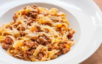 Pyszne tagliatelle z bogatym sosem mięsnym, posypane parmezanem. Idealny spaghetti bolognese przepis oryginalny na obiad.