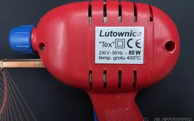 Czerwona lutownica "Tex" z niebieskim elementem, o mocy 80W i temperaturze grotu 400°C. Posiada oznaczenie CE, wskazujące na zgodność z normami bezpieczeństwa, w tym klasy ochronności.