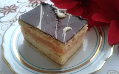 Pyszny kawałek ciasta z warstwami biszkoptu, kremu serowego i jabłek, oblany czekoladą. Idealny na przepis na ciasto delicja z serem i jabłkami.