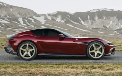 Czerwone Ferrari LaFerrari z złotymi felgami na tle górskich krajobrazów.
