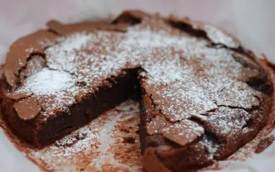 En saftig kladdkaka med pudersocker, perfekt för kladdkakans dag.