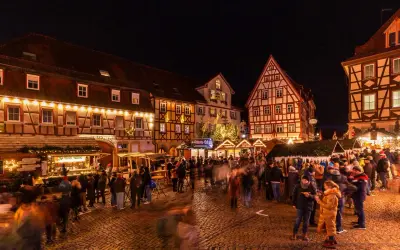 Bunte Lichter und geschäftiges Treiben auf dem **Bad Wimpfen Weihnachtsmarkt**. Fachwerkhäuser und Buden laden zum Verweilen ein.