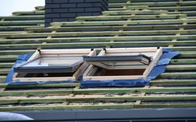 Dach prefabrykowany w budowie, z widocznymi oknami dachowymi i drewnianą konstrukcją.