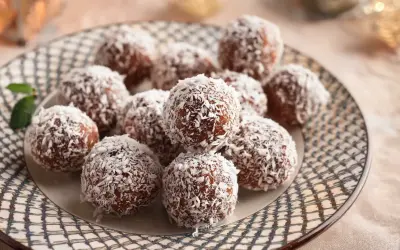 En tallrik med chokladbollar täckta av kokosflingor, redo att avnjutas. Ett enkelt chokladbollar recept för fika.