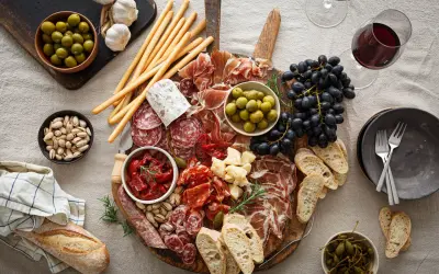 En generös bricka med italienska snacks: charkuterier, oliver, soltorkade tomater, ost, vindruvor, grissini och bröd. Perfekt för en mysig kväll.