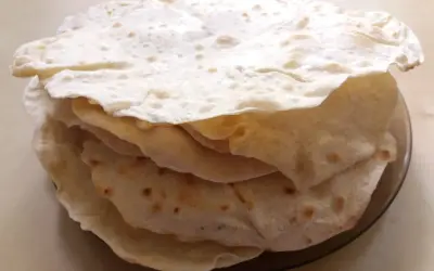Stos świeżo upieczonych placków tortilla, które wyglądają jak z oryginalnego przepisu. Idealne do wrapów i quesadilli.