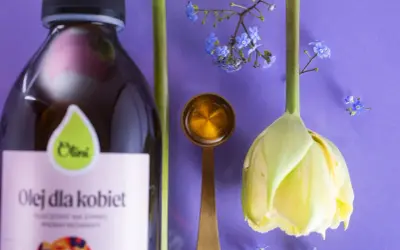Olej dla kobiet i kwiaty symbolizują naturalne sposoby na menopauzę. Złota łyżeczka z płynem sugeruje wsparcie w tym okresie.