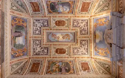 Soffitto affrescato della Certosa di Garegnano con scene sacre e decorazioni elaborate.