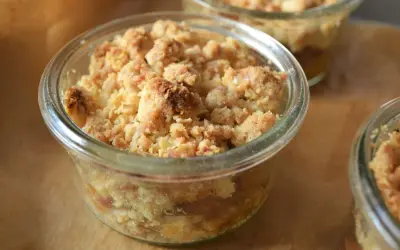 Ein köstlicher Apfel Crumble in einem Glas, mit knuspriger Streuseldecke und saftigen Äpfeln darunter.