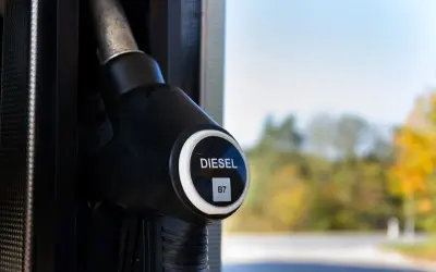 Dystrybutor paliwa z oznaczeniem DIESEL B7, sugerującym zawartość biodiesla. Tło rozmyte, jesienne drzewa.