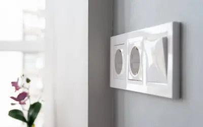 Instalación eléctrica moderna: cómo poner un enchufe donde no hay. Dos tomas de corriente y un interruptor en una pared gris.