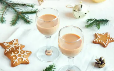 Dwa kieliszki z kremowym likierem nutella, ozdobione świątecznymi pierniczkami i gałązkami świerku.