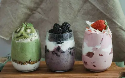 Trzy desery w szklankach: zielony z kiwi, fioletowy z jeżynami i różowy z truskawkami. Idealne na dietę South Beach.
