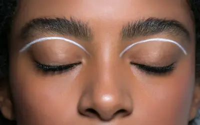 Oczy z makijażem w stylu cut crease, podkreślone białymi liniami nad powiekami.