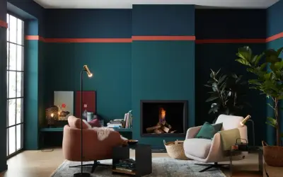 Moderne Wohnzimmer-farbgestaltung wand mit petrol, dunkelblau und korallenroten Akzenten. Gemütliche Sessel und Kamin sorgen für Wohlfühlatmosphäre.