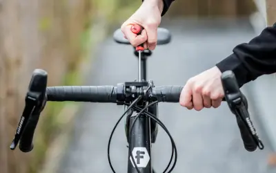 Hände stellen den MTB Lenker ein. Mit einem Schraubenzieher wird die Lenkerposition justiert, um die perfekte Fahrt zu ermöglichen.