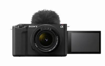 Czarny aparat Sony Alpha z obiektywem i futrzanym mikrofonem. Idealny do vlogowania, model zve1.