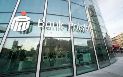 Logo PKO Bank Polski na szklanej fasadzie. W środku wnętrze banku, gdzie można założyć pko bp lokaty.