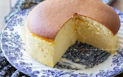 Una soffice torta giapponese, dorata in superficie e chiara all'interno, servita su un piatto decorato con un motivo blu e bianco.