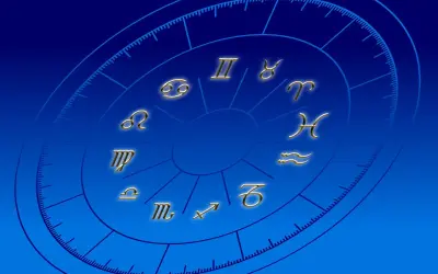 Złote symbole zodiaku na niebieskim tle. Praktykowanie magii i horoskopów może wpływać na życie duchowe katolika, odciągając od wiary.