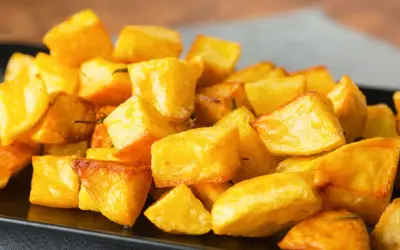 Un piatto invitante di patate al forno croccanti, dorate e saporite, pronte per essere gustate.
