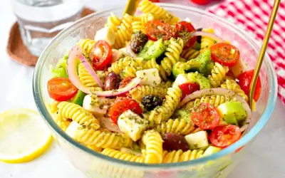 En härlig grekisk pastasallad med fusilli, körsbärstomater, fetaost, oliver och rödlök. Perfekt för en lätt lunch eller middag.