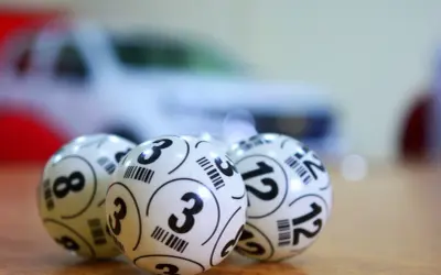 Trzy białe kulki z numerami 3, 8 i 12. Zastanawiasz się, ile idzie przelew z lotto online?