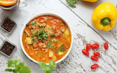 Aromatic gulasz, idealny na dietę trzustkową, z kawałkami mięsa, ziemniaków i papryki, ozdobiony natką pietruszki.