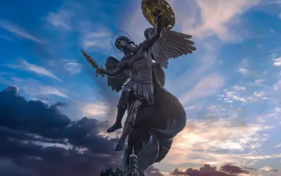 Pomnik św. Michała Archanioła z mieczem i tarczą na tle nieba.