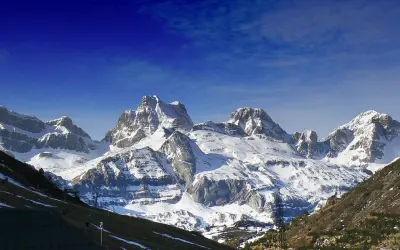 Majestuosas cumbres nevadas en Candanchú, un paisaje de verano que invita a la aventura.