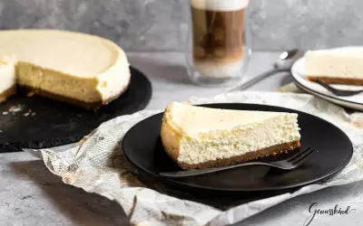 Ein Stück New York Cheesecake, cremig und auf einem Keksboden, wartet auf dich. Dieses Rezept ist ein Genuss!