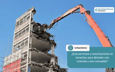 Grúa naranja realiza demoliciones de edificios. Se pregunta sobre permisos para demoler inmuebles.