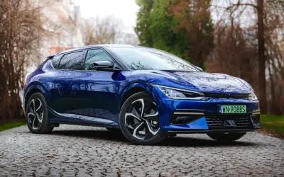 Niebieska Kia EV6 na kamienistej drodze, gotowa do testu. Elegancki design i nowoczesna technologia.