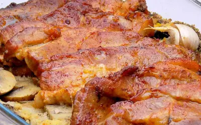 Soczysta karkówka z pieczarkami i cebulą z piekarnika, pachnąca czosnkiem. Idealna na obiad.