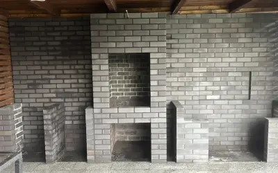 Nowy, murowany prosty grill z cegły czeka na pierwsze rozpalenie. Wygodny, z miejscem na drewno i akcesoria.
