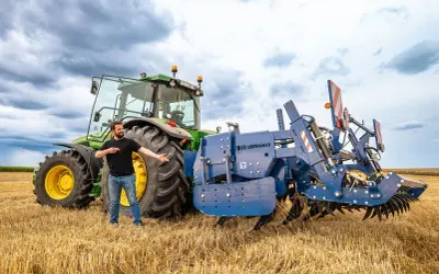 Un homme présente une charrue Rolmako, un outil agricole essentiel pour préparer les sols. La sep charrue définition est ici illustrée par cet équipement robuste.