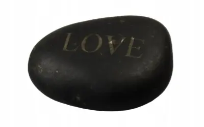 Czarny, gładki kamień z wygrawerowanym napisem "LOVE". Dałem ci kamień z wielkim love tekst, jako symbol naszej więzi.