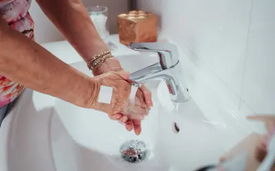 Hände waschen mit Pflaster auf einer kleinen wunde. Ein Hausmittel zum wasserdicht abdecken ist hier zu sehen.