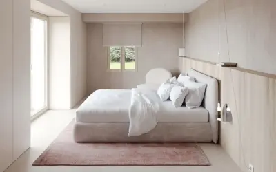 Chambre épurée avec lit blanc, tapis rose poudré et bois clair. Une belle inspi déco chambre pour un cocon de douceur.
