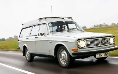 Grå Volvo 145 Express med takräcke kör på en väg.