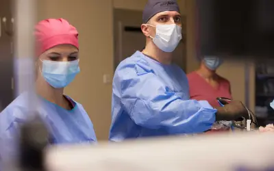 Chirurdzy w maseczkach i fartuchach podczas operacji.