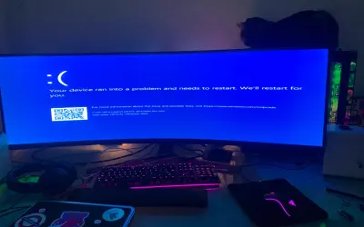 Niebieski ekran Windows 10 z komunikatem "CRITICAL PROCESS DIED". Komputer się zawiesił, a kot obserwuje sytuację z góry.